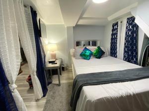 ウエスト・ニューヨークにあるOasis in New Jersey - 2BR NYC Accessのベッド2台、テーブル(ランプ付)が備わる小さな客室です。 +60枚の写真