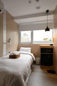 a bedroom with two beds and a window at Poshpacker Hotel in Taipei