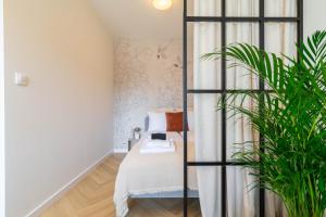 a bedroom with a bed and a plant at Good Mood Francuska Retreat - FREE PARKING - Self check-in in Katowice