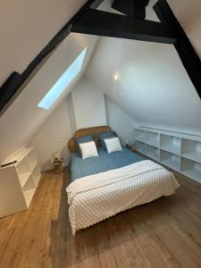 a bedroom with a bed in a attic at Le cottage champêtre in Escaudoeuvres