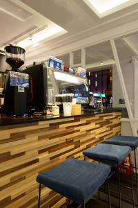 un restaurante con un mostrador con 2 asientos azules en Poshpacker Hotel en Taipéi