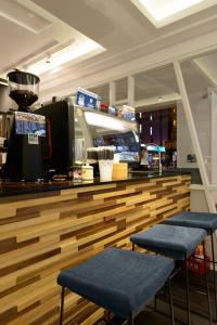 a restaurant with a counter with two blue seats at Poshpacker Hotel in Taipei