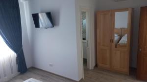 a room with a door and a television on a wall at Pensiunea Alicia in Jurilovca
