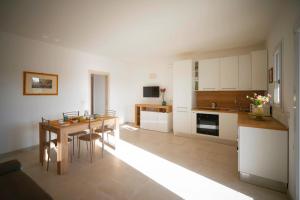 Una cocina con una mesa y un comedor. en Dimore degli Ulivi, en Leporano