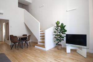 a living room with a tv and a table with chairs at Santo Stefano Loft in Bologna
