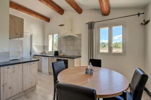 a kitchen with a wooden table and chairs at Clos Saint-Michel Resort & Spa in Malaucène