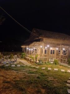 une maison avec des lumières allumées la nuit dans l'établissement K50 Waterfall Village - Homestay Măng Đen, à Kon Plong