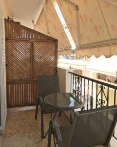 a patio with a table and chairs on a balcony at Rigas Apartment in Artemida