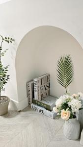 a pile of books sitting on a table with flowers at Honey Sleep Room - 2BR Cosy House at Jamsil, FreeParking in Seoul