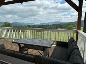 a couch and a table on a deck with a view at domki-sopotnia in Sopotnia Wielka
