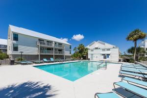a swimming pool with lounge chairs and a building at Cotton Bayou Unit 8C in Orange Beach