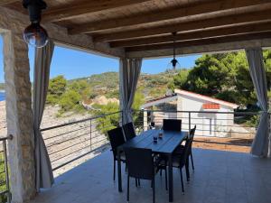 ein Esszimmer mit Tisch und Stühlen auf einem Balkon in der Unterkunft SOL ET PAX in Drvenik Veli + 20 Fotos