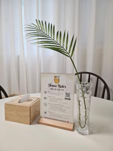 a table with a book and a vase and a box at Honey Sleep Room - 2BR Cosy House at Jamsil, FreeParking in Seoul +21 photos