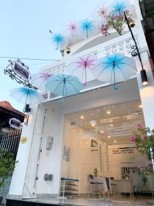 a group of blue umbrellas hanging from a building at Timothy House Hue in Hue
