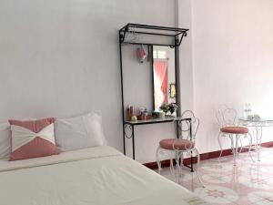 a bedroom with a bed and a mirror and a table at Timothy House Hue in Hue +79 photos