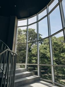 a room with a large window and stairs at Optima Collection Chernivtsi in Chernivtsi