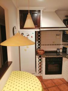 cocina con nevera blanca y mesa amarilla en O Piso dos Avós, en A Guarda 15 fotos más