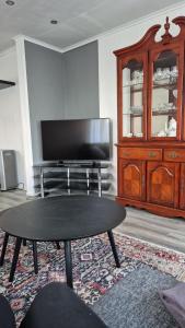 a living room with a table and a entertainment center at Duzy apartament w centrum Ålesund in Ålesund