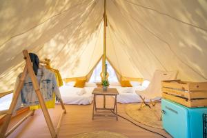 a tent with a bed and a table in a room at Kampaoh Delta del Ebro in Poblenou del Delta