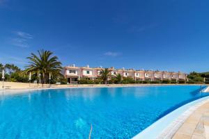 a large blue swimming pool with buildings in the background at Cascais, Vila Bicuda in Cascais
