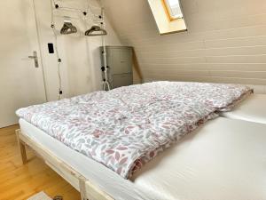 a hospital bed with a blanket on it in a room at Fachwerkhaus im Landhausstil in Staufenberg +2 photos
