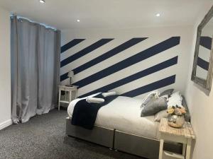 a bedroom with a bed with blue and white stripes at Liverpool city central 2 bedroom apartment in Liverpool