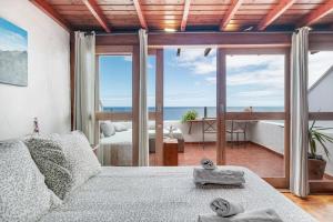 a bedroom with a bed with a view of the ocean at Casa Roque in Haría