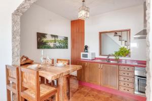 a kitchen with a wooden table and a sink at Casa Roque in Haría +16 photos