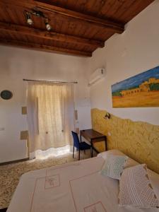 a bedroom with a bed and a table and a window at La casa di Paolina in Palazzolo Acreide