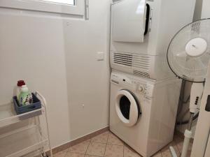 a laundry room with a washing machine and a fan at Casa Renoir - Schritte zum Zee in Locarno