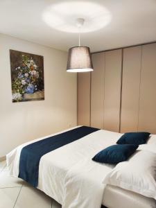 a bedroom with a large white bed with blue pillows at Casa Renoir - Schritte zum Zee in Locarno