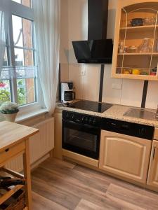 a small kitchen with a stove and a table at Heide-Ferienwohnung-Soltau in Soltau