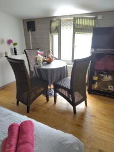 a room with a table and chairs and a fireplace at Rosemary Cottage in Sergines