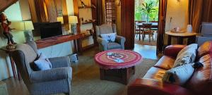 a living room with a couch and chairs and a table at Dar Amane Guest House in Graskop
