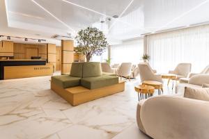 a lobby with a couch and chairs and tables at Natura All Seasons Boutique Hotel in Burgas City