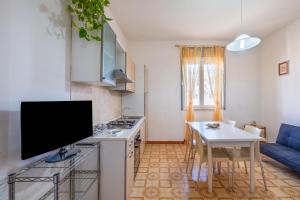 cocina con fogones y mesa con TV en Casa vacanze Colopi, en Gallipoli