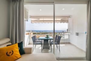 a living room with a table and chairs and a balcony at Ponderosa 611, Las Americas, one bedroom apartment with large terrace and ocean view, next to Siam Park in Playa Fañabe