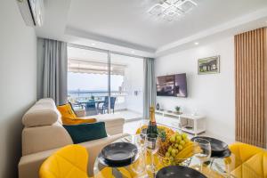 a living room with a couch and a table at Ponderosa 611, Las Americas, one bedroom apartment with large terrace and ocean view, next to Siam Park in Playa Fañabe