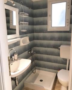 a bathroom with a sink and a toilet at Rigas Apartment in Artemida +7 photos
