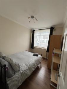 a small bedroom with a bed and a window at 20mins to BakerSt, Harry Potter & Wembley Stadium! in Northwood