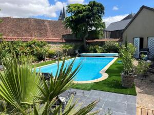 a swimming pool in the backyard of a house at Relais Saint-Jean Levroux in Levroux