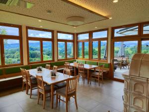 a dining room with tables and chairs and windows at Weingut Fellner in Leutschach
