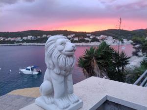 a white lion statue sitting on top of a building at Apartments Ranko in Zavalatica