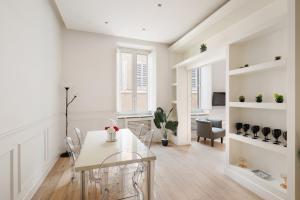 ein weißes Esszimmer mit Tisch und Stühlen in der Unterkunft Crystal Home Piazza Navona in Rom