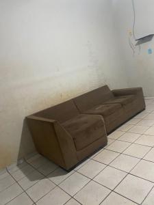 a brown couch sitting in the corner of a room at Casa com garagem in Acailandia