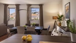 a dining room with a table and chairs and windows at La Grisha in Mali Lošinj +3 photos