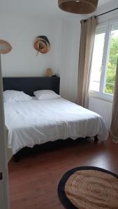 a bedroom with a white bed and a window at Gite Les 4 Fleurs in Le Puy en Velay