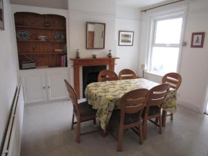 a dining room with a table and chairs and a fireplace at Yarborough in East Cowes