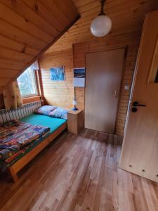 una camera con un letto e una porta di Velo Domki i Pokoje NadZamkiem a Czorsztyn