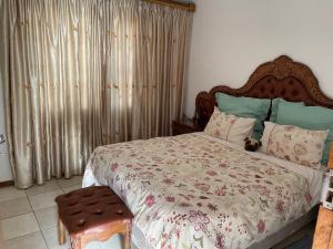 a bedroom with a bed and a chair and curtains at Ben Kalulu House in Mangeti